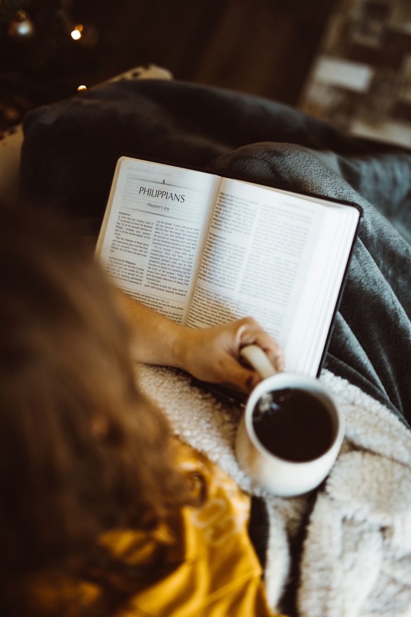Photo by Nathan Dumlao person holding white ceramic mug while reading book